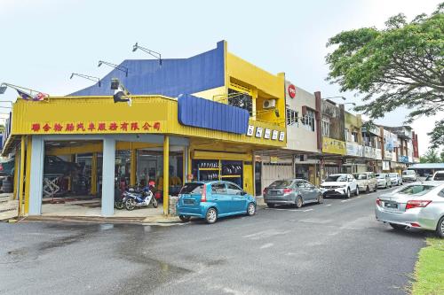 una strada con auto parcheggiate davanti agli edifici di Hotel O S Homestay a Kuantan