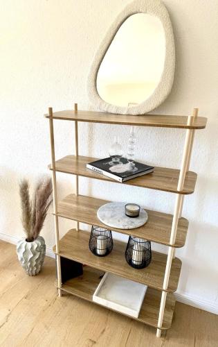 a wooden shelf with a mirror on a wall at Allgäu Boho Apartment mit Balkon in Kempten