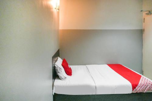 a bedroom with a bed with a red and white blanket at Hotel O 365 Nice Stay in Miri