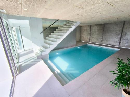 a swimming pool in a house with a staircase at Casa Manolo de Amparo in Vimianzo