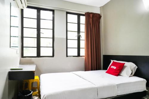a bedroom with a bed with a red pillow on it at Hotel O 365 Nice Stay in Miri