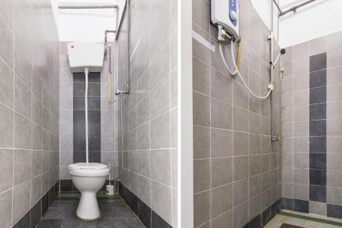 a bathroom with a toilet and a shower at Hotel O Kuantan Backpackers in Kuantan