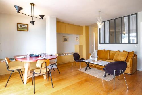 un salon avec une table et un canapé dans l'établissement Appartement Invalides avec Terrasse, à Paris