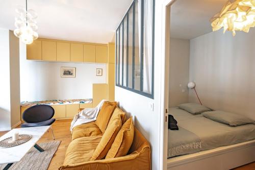 Cette petite chambre comprend un lit et une chaise. dans l'établissement Appartement Invalides avec Terrasse, à Paris
