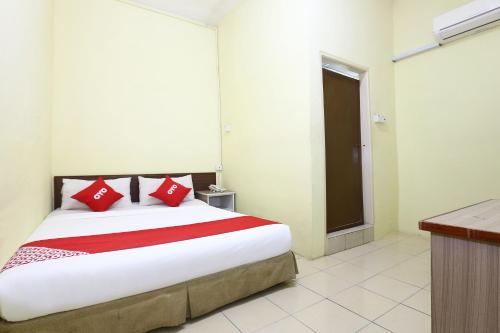 a bedroom with a large bed with red pillows at Hotel O Harmoni Hotel in Kota Bharu