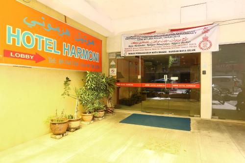 a hotel entrance with potted plants outside of a building at Hotel O Harmoni Hotel in Kota Bharu