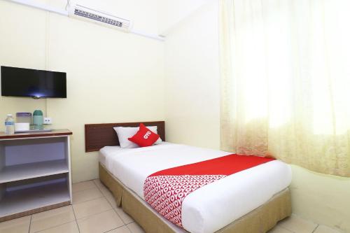 a bedroom with a bed and a television in it at Hotel O Harmoni Hotel in Kota Bharu