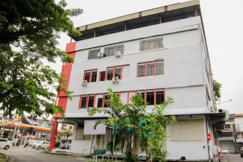 a white building with red windows at OYO 1173 Mandyrin Hotel in Sibu