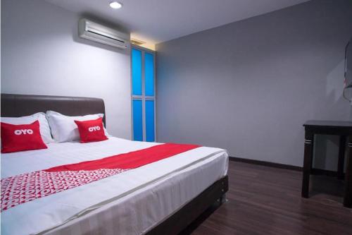 a bedroom with a bed with red pillows on it at Hotel O Taj (seksyen 13) in Shah Alam