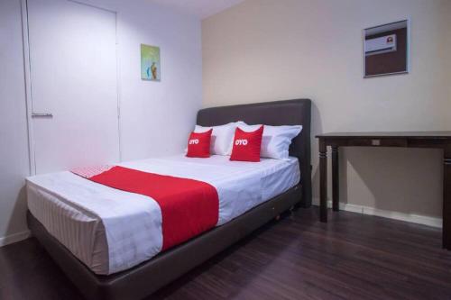 a bedroom with a bed with red pillows on it at Hotel O Taj (seksyen 13) in Shah Alam