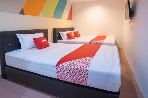 two beds sitting next to each other in a room at Hotel O Taj (seksyen 13) in Shah Alam