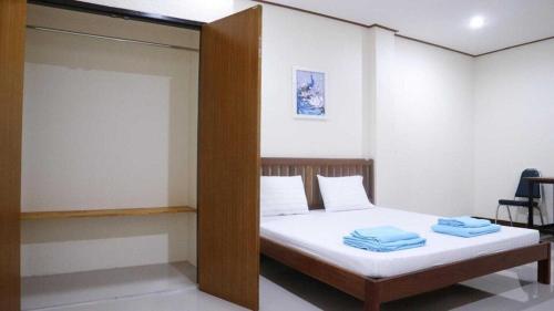 a bedroom with a bed with two towels on it at Capital O 75521 Sang Siri Apartment in Samut Songkhram