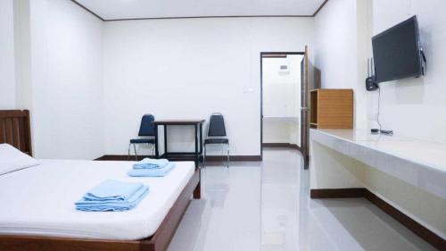a hospital room with a bed and a tv at Capital O 75521 Sang Siri Apartment in Samut Songkhram