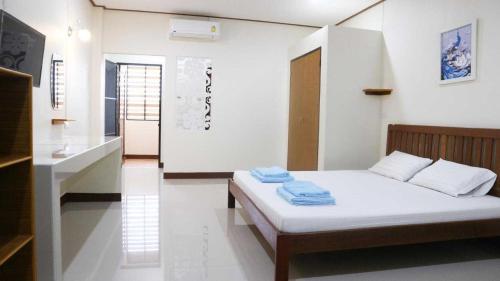 a bedroom with a bed with towels on it at Capital O 75521 Sang Siri Apartment in Samut Songkhram