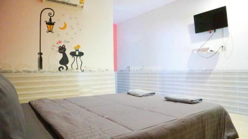 a bedroom with a bed and a tv in it at The Moon Resort Phetchaburi in Phetchaburi