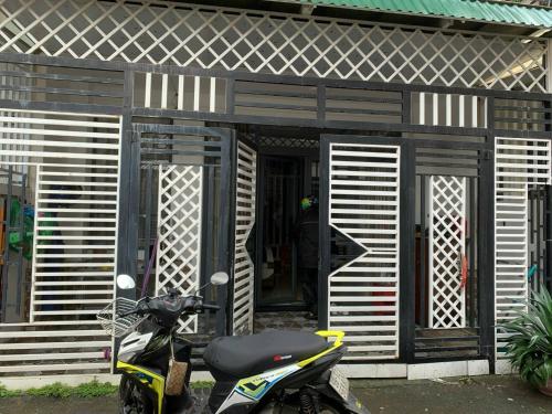une moto garée devant une maison dans l'établissement OYO 1248 Quyen House, à Đà Lạt