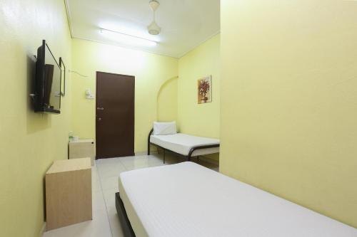 a hospital room with a bed and a chair at Hotel O Innap Kota Bharu in Kota Bharu