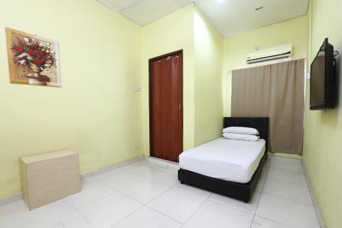 a small room with a bed and a television at Hotel O Innap Kota Bharu in Kota Bharu