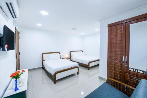 a room with two beds and a table with flowers at Capital O 90543 Sp Star Hotel in Sungai Petani