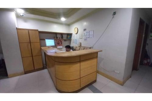 een kind aan een aanrecht in een keuken bij OYO 1066 Dorotello Apartelle in Manilla