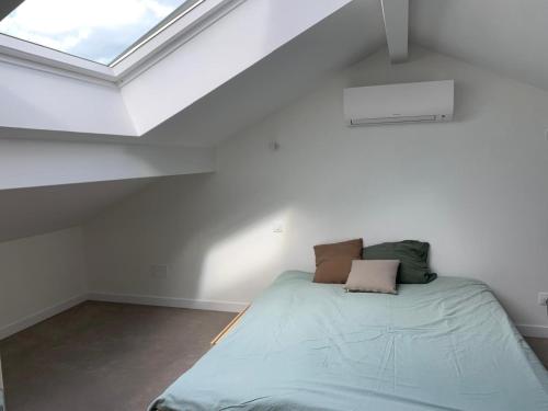 une chambre avec un lit dans un grenier dans l'établissement Azkena, à Anglet