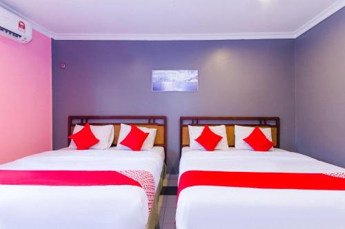 two beds sitting next to each other in a room at Hotel O Comfort in Ipoh