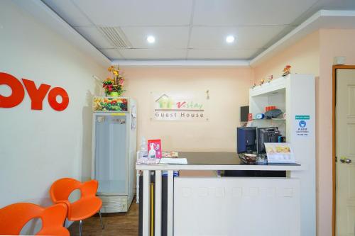 a kitchen with orange chairs and a counter top at Hotel O V Stay Guesthouse in Ayer Itam