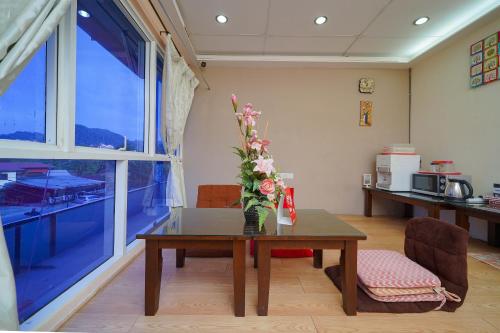 a room with a table with a vase of flowers on it at Hotel O V Stay Guesthouse in Ayer Itam