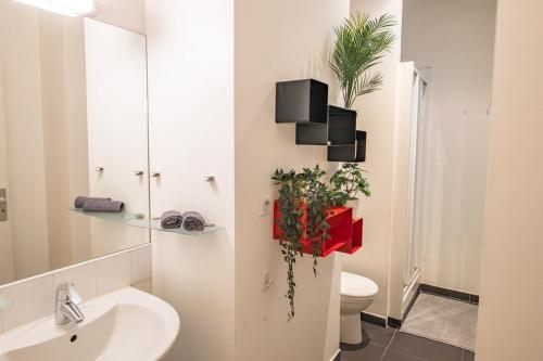 La salle de bains est pourvue d'un lavabo, de toilettes et de plantes. dans l'établissement Elegant Duplex Montorgueil - 6 Guests, à Paris