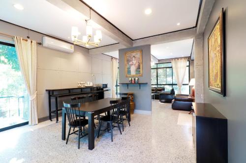 a dining room and living room with a table and chairs at Capital O 464 At Nata Chiangmai Chic Jungle in Mae Rim