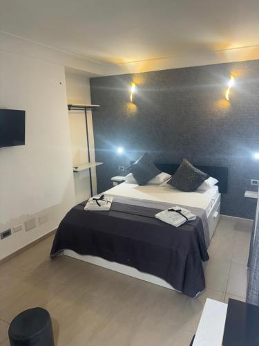 una camera da letto con un letto, due tavoli e luci di Pisacane Family Sea a Napoli