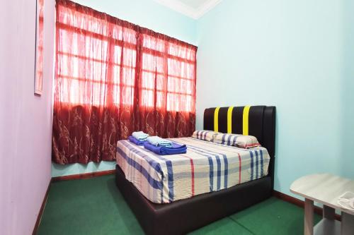 a bedroom with a bed in a room with a window at Hotel O Sosodikon Inap Desa in Ranau