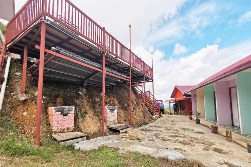 a building with a staircase on the side of it at Hotel O Sosodikon Inap Desa in Ranau