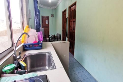 a kitchen with a sink and a counter top at Hotel O Sosodikon Inap Desa in Ranau