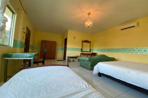 a bedroom with two beds and a sink and a mirror at Hotel O Rb Homestay & Farms in Kuching