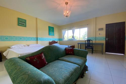 a living room with a couch and a bed at Hotel O Rb Homestay & Farms in Kuching