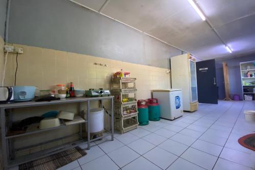 a kitchen with a counter and a refrigerator at Hotel O Rb Homestay & Farms in Kuching
