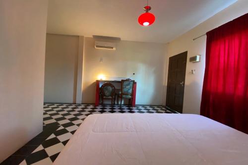 a bedroom with a bed and a red curtain at Hotel O Rb Homestay & Farms in Kuching
