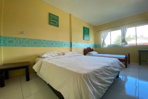 a bedroom with a large bed and a window at Hotel O Rb Homestay & Farms in Kuching