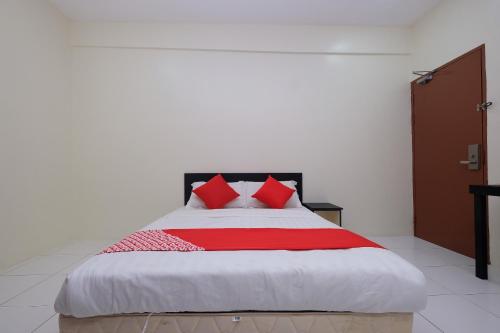 a bedroom with a large bed with red pillows at OYO 1104 Q Hotel in Temerloh