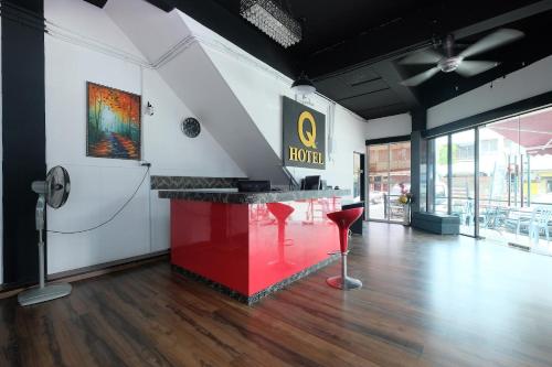 a hotel lobby with a red counter and red stools at OYO 1104 Q Hotel in Temerloh