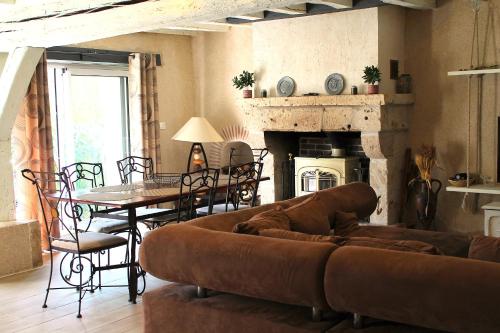 - un salon avec un canapé, une table et une cheminée dans l'établissement les Refuges du Vignoble, à Limeray