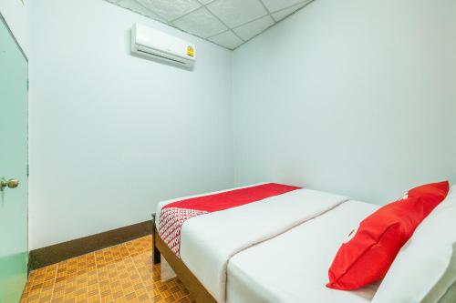 Un dormitorio con una cama con almohadas rojas. en OYO 608 Maleena Home, en Krabi