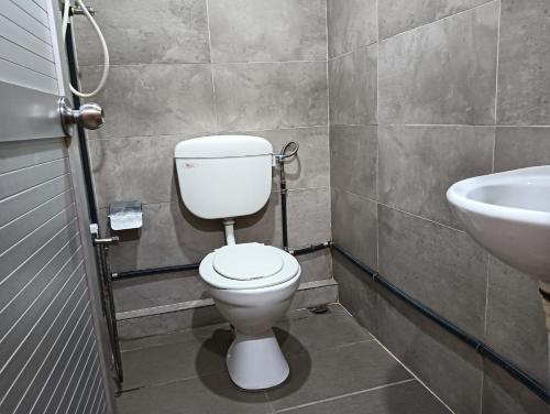 a bathroom with a toilet and a sink at Hotel O Hi Inn 2 in Sibu
