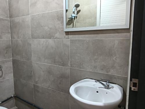 a bathroom with a sink and a mirror at Hotel O Hi Inn 2 in Sibu