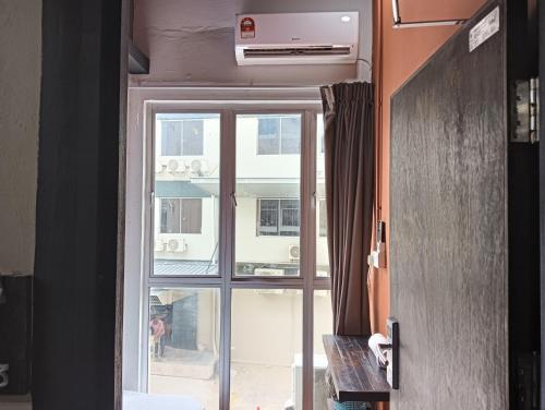 a door to a window with a view of a building at Hotel O Hi Inn 2 in Sibu