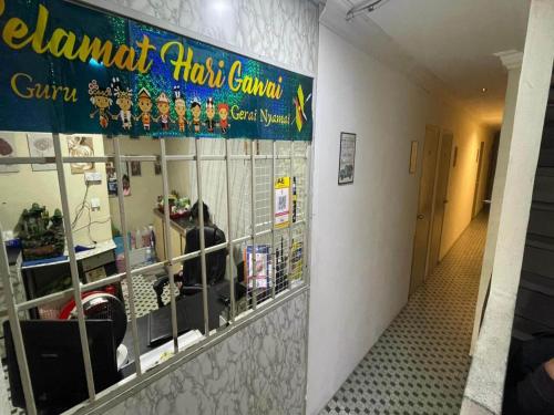 a restaurant with a sign on a wall with mirrors at Hotel O 59 in Sibu