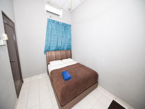 a small bed in a small room with a blue pillow at Hotel O Iman Roomstay Gua Musang in Gua Musang