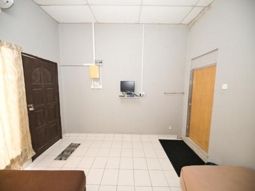 an empty room with a door and a tv at Hotel O Iman Roomstay Gua Musang in Gua Musang