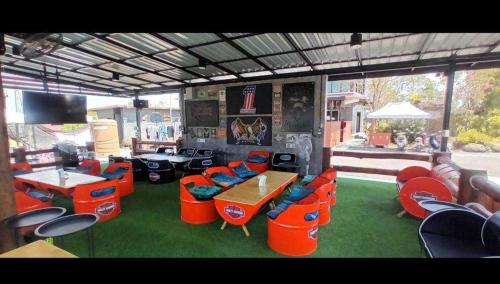 a room with orange chairs and a table and a group of tables and chairs at OYO 75500 Kuunone Art & Gallery in Chiang Mai